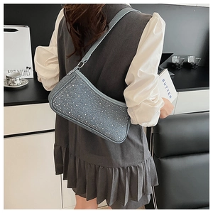 Dettaglio della borsa a mezzaluna in denim blu con strass argentati e borchie in metallo