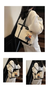Detail of minimalist woven tote bag with leather handles and cute plush bear charm