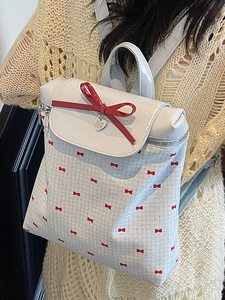 Zaino capiente color crema con fiocchi rossi e ciondolo a cuore per il viaggio