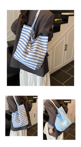 Détail du sac cabas réversible en toile rayée avec logo en cuir et grande capacité