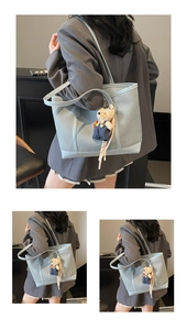 Detail view of a light blue woven tote bag with a cute bear charm for daily commuting