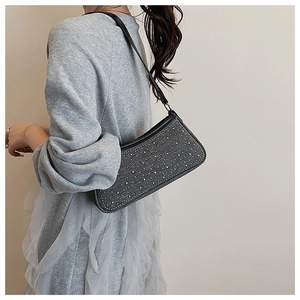 Vista dettagliata della borsa a spalla in denim con borchie d'argento e tracolla nera
