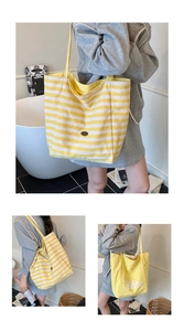 Détail du sac cabas en toile réversible à rayures jaunes avec logo et grande capacité
