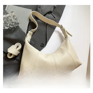 Detail of creamy white pebble leather hobo bag showing vertical stitching and texture