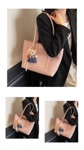Detail of pink faux leather tote bag with twill weave texture and teddy bear pendant