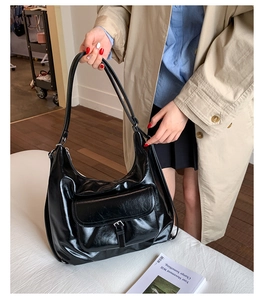 Close-up of the vintage black oily leather hobo bag featuring a flap pocket and metal buckle
