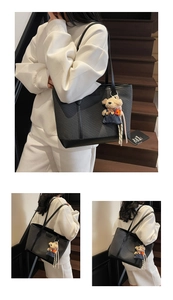 Detail of black woven tote bag with smooth leather base and cute denim bear charm