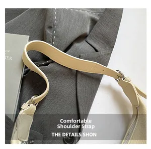Close-up of beige lychee grain leather shoulder strap with silver hardware and neat stitching