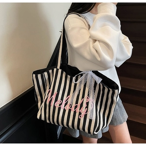 Gros plan du sac en toile rayé avec texte Melody rose et nœud en dentelle élégant