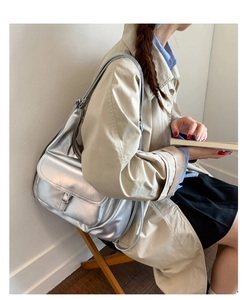 Silver metallic tote bag detail showing flip-top buckle and futuristic texture
