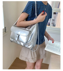 Metallic silver tote bag detail with front buckle pocket and sleek shoulder strap