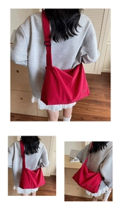 Detail view of red large capacity canvas crossbody bag with BNT letter embroidery decoration