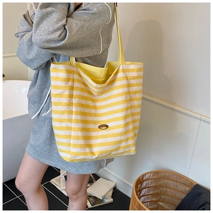 Détail du sac cabas en toile rayée avec plaque en métal Handmade et motif jaune vif