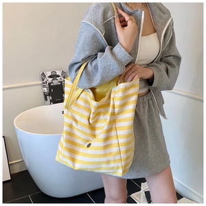Détail du sac cabas en toile rayé jaune et blanc montrant le fermoir magnétique interne