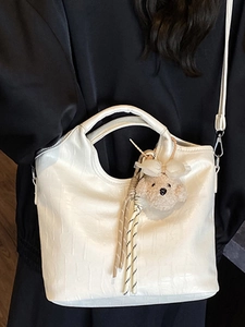 Borsa a secchiello bianca minimalista con stampa coccodrillo e ciondolo a orsetto