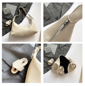 Detail of beige grained leather hobo bag showing zipper, strap stitching and interior space