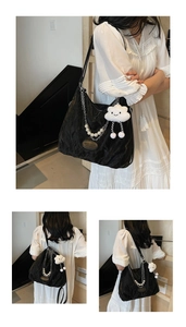 Close-up of black cloud-textured shoulder bag with silver chain and pearl charms