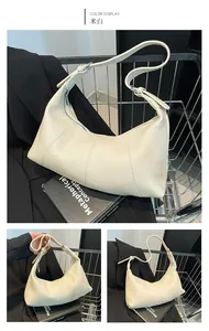 Detail view of cream white baguette bag featuring pebbled leather texture and silver zipper