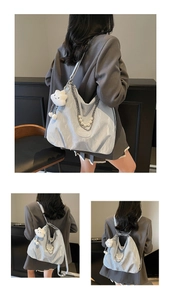 Detail of light blue tote bag with silver chain, pearl strap and plush cloud charm