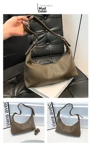Detail of mud color leather shoulder bag featuring vertical stitching and adjustable strap