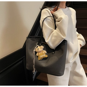 Détail du sac cabas noir avec tissu en sergé texturé et pendentif ours en peluche