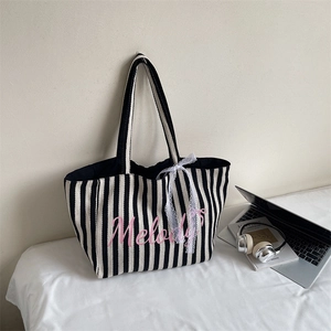 Détail du cabas en toile rayé avec imprimé Melody rose et nœud en dentelle décoratif