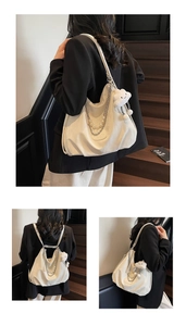 Detail of white PU leather bag with decorative metal chain and pearl strand accessories