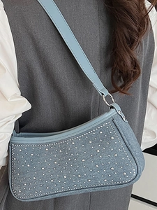 Borsa sottobraccio in denim azzurro vintage con borchie in metallo e tracolla lunga