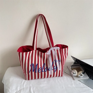 Détail du sac cabas en toile à rayures rouges avec broderie Melody et nœud en dentelle