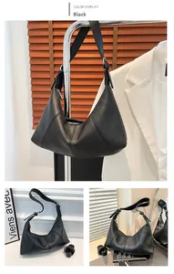 Detail of black lychee grain leather hobo bag with silver zipper and wide strap