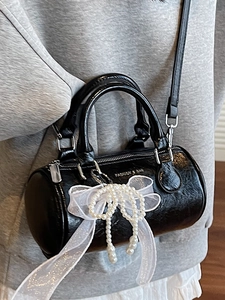 Chic black cylinder handbag with lace bow and pearl charms for a trendy look