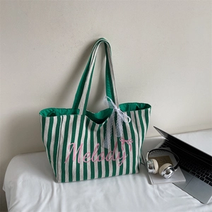 Détail du sac cabas rayé vert en toile avec imprimé rose Melody et nœud en dentelle