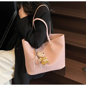 Détail du sac cabas rose avec texture diagonale et charmant pendentif en forme d'ours