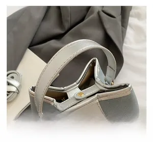 Detail showing silver leather handle and metal turn-lock closure on light blue bucket bag