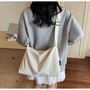 Detailed back view of a beige canvas travel bag showing its texture and wide strap