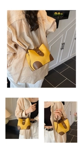 Detail view of yellow canvas and brown leather bucket bag with vintage gold hardware buckle