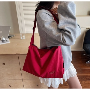 Detail of red large capacity canvas bag with BNT embroidery and adjustable strap