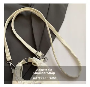 Detail of an adjustable cream leather shoulder strap with polished silver metal hardware