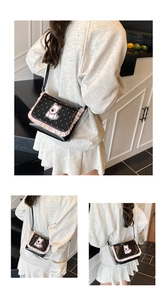 Close-up of black square flap bag with cartoon dog embroidery and pink frill details