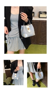 Detail shot of light blue denim bucket bag with silver leather trim and gold twist lock