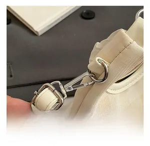 Detail shot of the silver metal hook and textured cream fabric on a bucket bag
