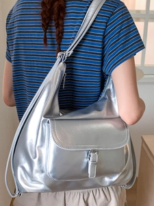 Metallic silver tote bag with large capacity for women shown on a model in a casual setting