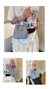 Detail view of light blue bucket bag with gold clasp and textured matte leather finish