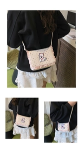 Detail of beige polka dot shoulder bag with dog embroidery and pink ruffle trim