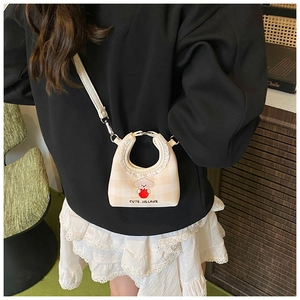 Detail of cute puppy embroidery on beige checkered mini bucket bag with leather strap