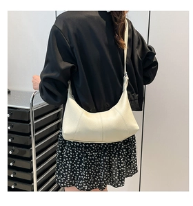 Detail view of cream crescent shoulder bag featuring premium lychee grain leather texture