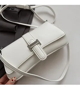 Detail showing white baguette bag texture with silver metallic buckle and adjustable strap
