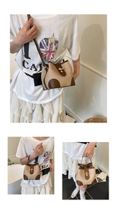 Detail view of canvas bucket bag with brown leather trim and rotating metal lock