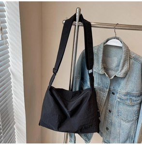 Detail of black nylon messenger bag with BNT embroidery and adjustable wide shoulder strap