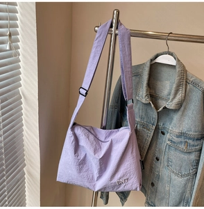 Detailed shot of lavender nylon bag with BNT embroidery on adjustable wide strap